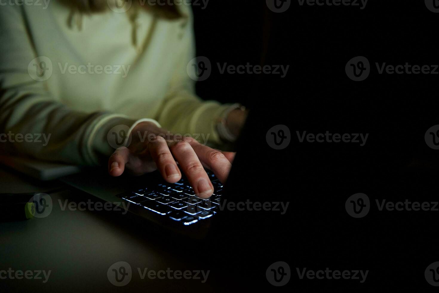 Anonymous woman working on laptop at night photo