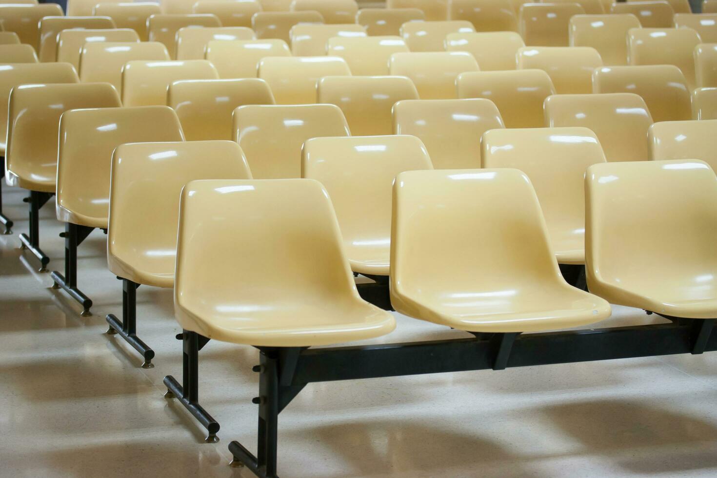 empty yellow plastic chairs in many rows photo