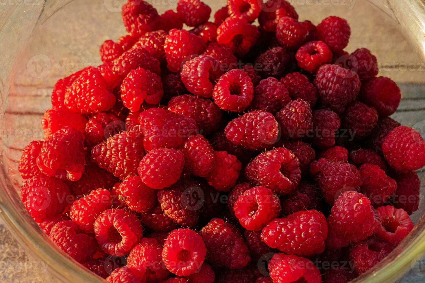 Raspberries in a glass bowl close-up. Berries of red ripe raspberries. photo