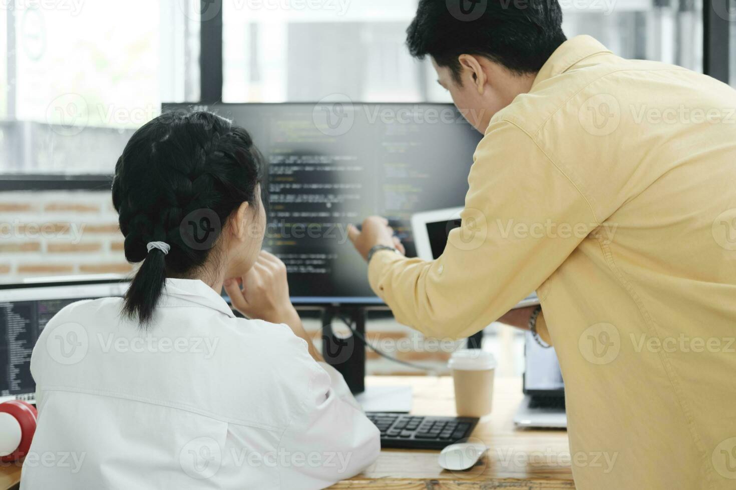 equipo de joven computadora programadores cooperando mientras trabajando en escritorio ordenador personal en el oficina. foto