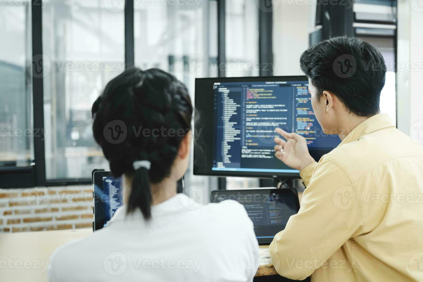 equipo de joven computadora programadores cooperando mientras trabajando en escritorio ordenador personal en el oficina. foto