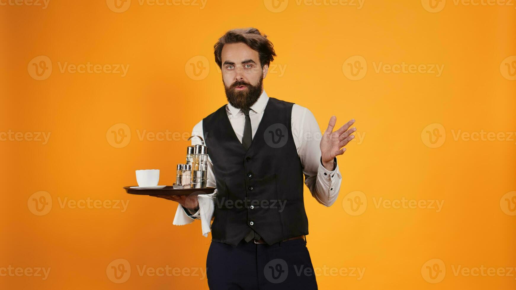 Shocked waiter with surprised reaction carrying coffee and cutlery of meal tray, being in shock on camera. Skilled elegant butler givign assistance to clients, experiencing surprise. photo