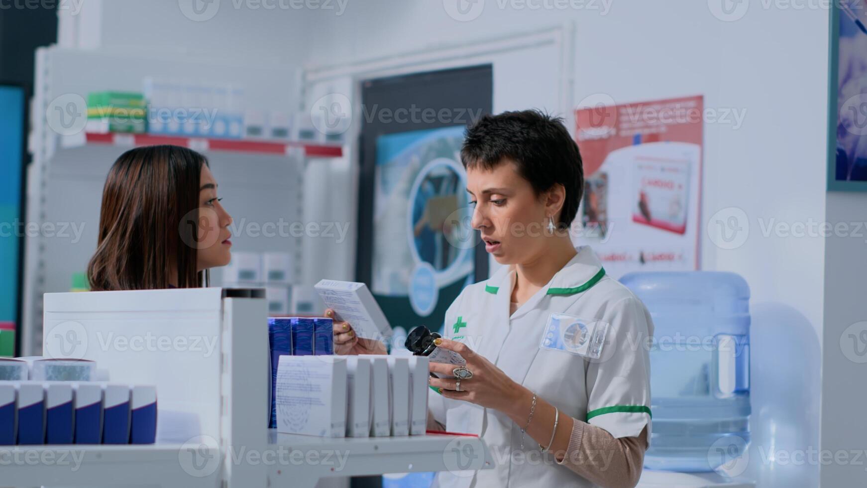 Healthcare expert taking break from arranging merchandise on shelves to help customer with medical suggestions. Shopper wishing to purchase pharmacological product, asking pharmacist for advice photo