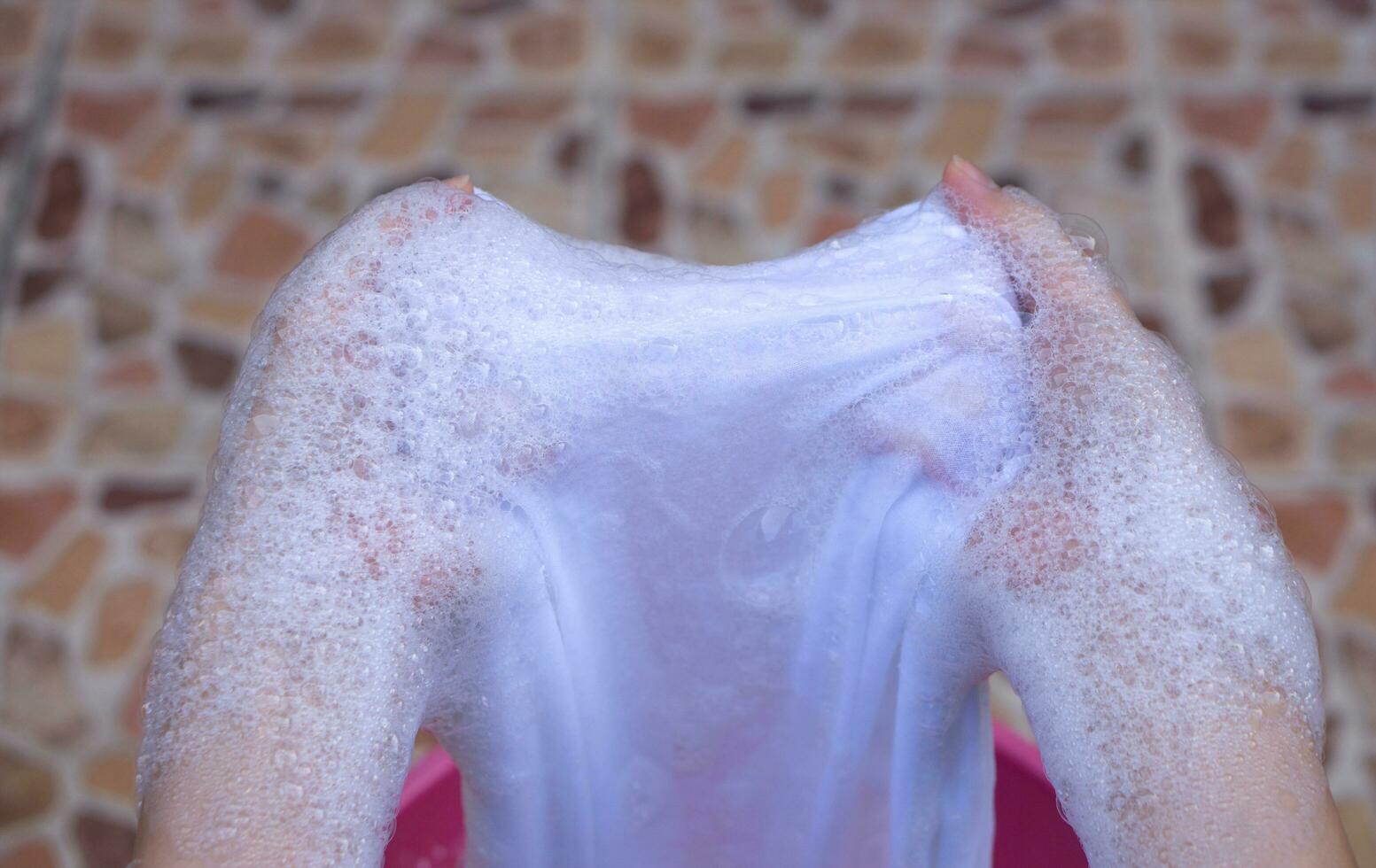 Hand washing clothes in the basin. photo