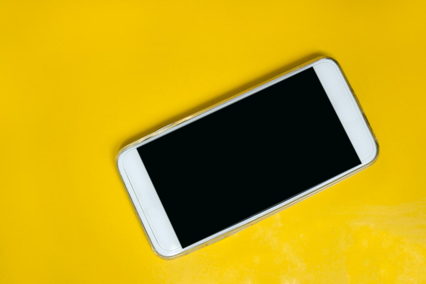white smart phone on yellow table photo