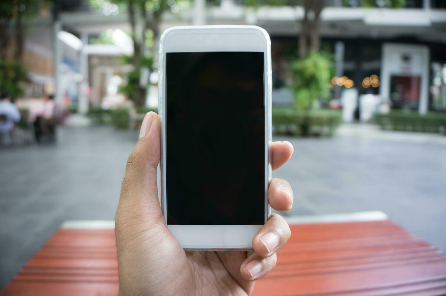 Man's hand shows mobile smartphone in vertical position photo