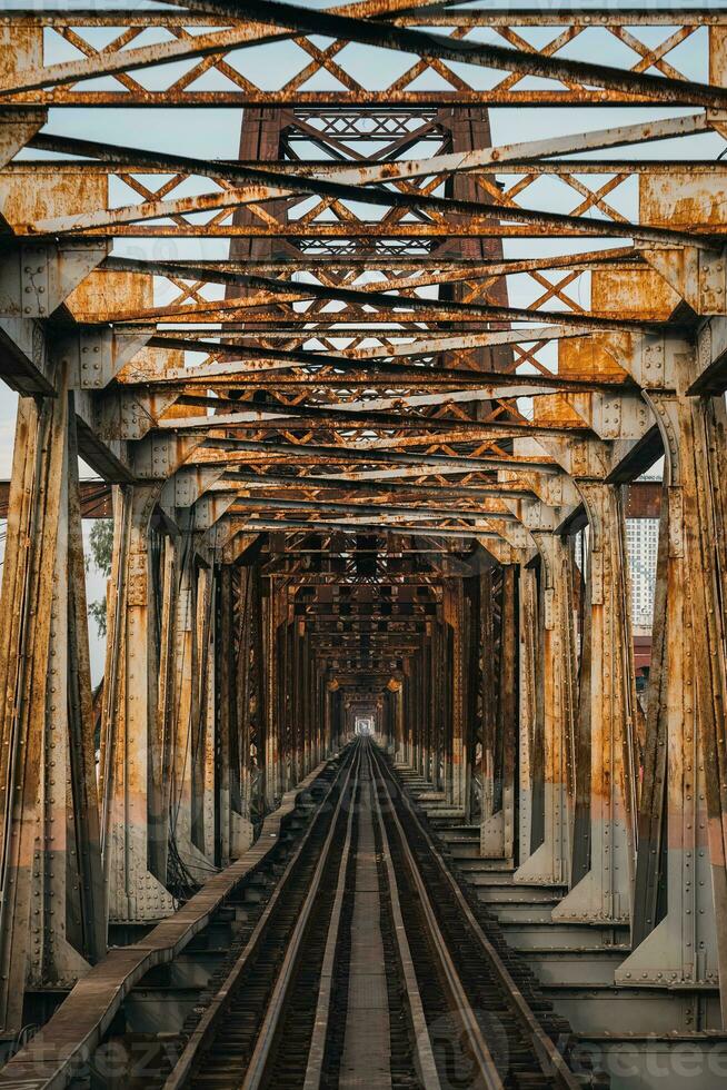 antiguo oxidado hierro tradicional ferrocarril largo bien puente estructura terminado el la carretera en Hanoi ciudad foto