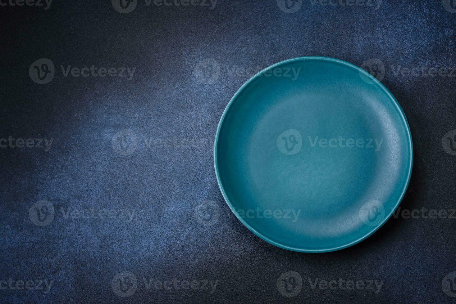 Round empty colored ceramic plate on concrete texture background photo