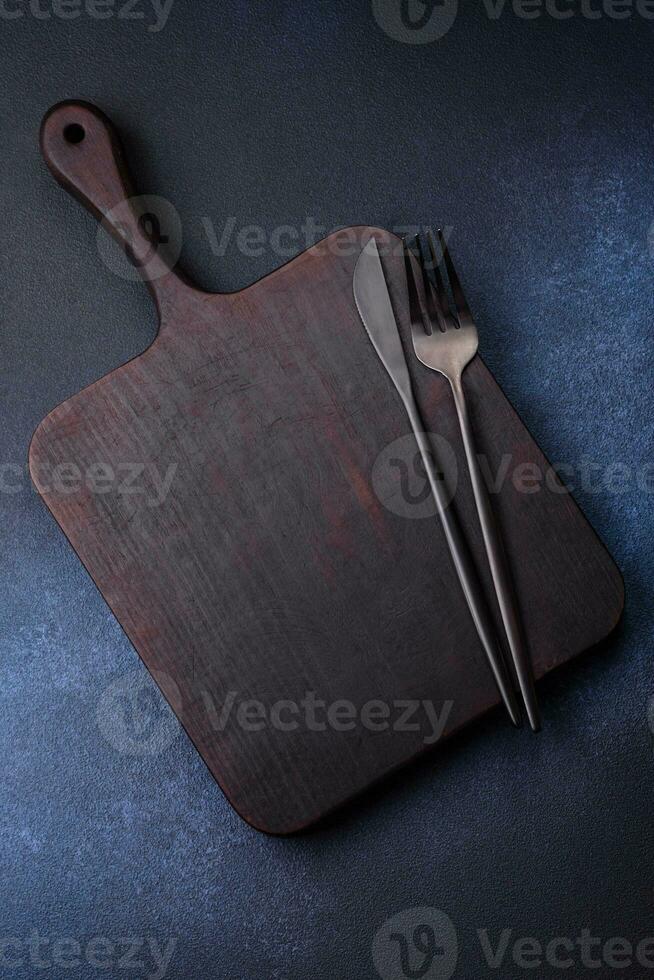 Empty rectangular wooden cutting board on dark concrete background photo