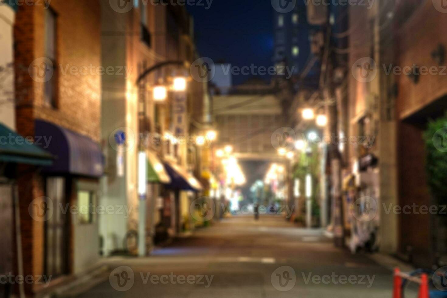 Blurred scene of alleyway with light glowing at night photo