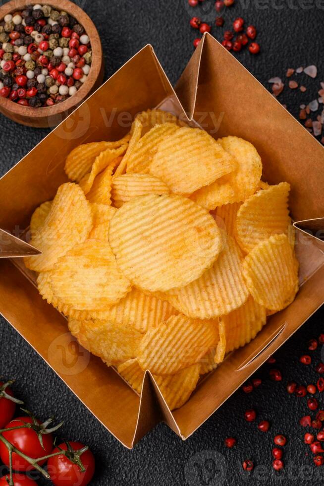 Crispy potato chips with salt, spices and herbs photo