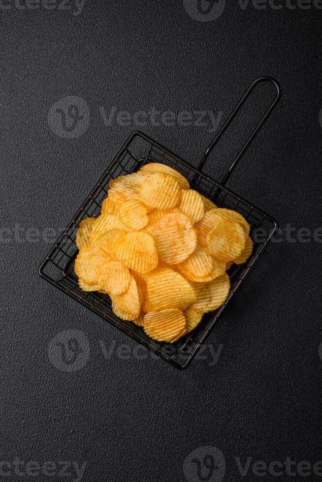 Crispy potato chips with salt, spices and herbs photo
