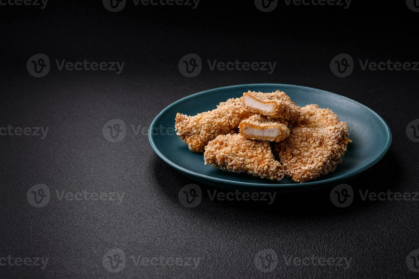 deliciosos nuggets de pollo crujientes y frescos sobre un fondo de hormigón oscuro foto