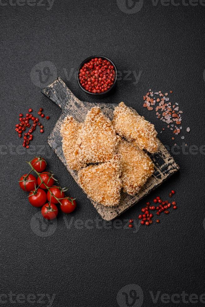 deliciosos nuggets de pollo crujientes y frescos sobre un fondo de hormigón oscuro foto