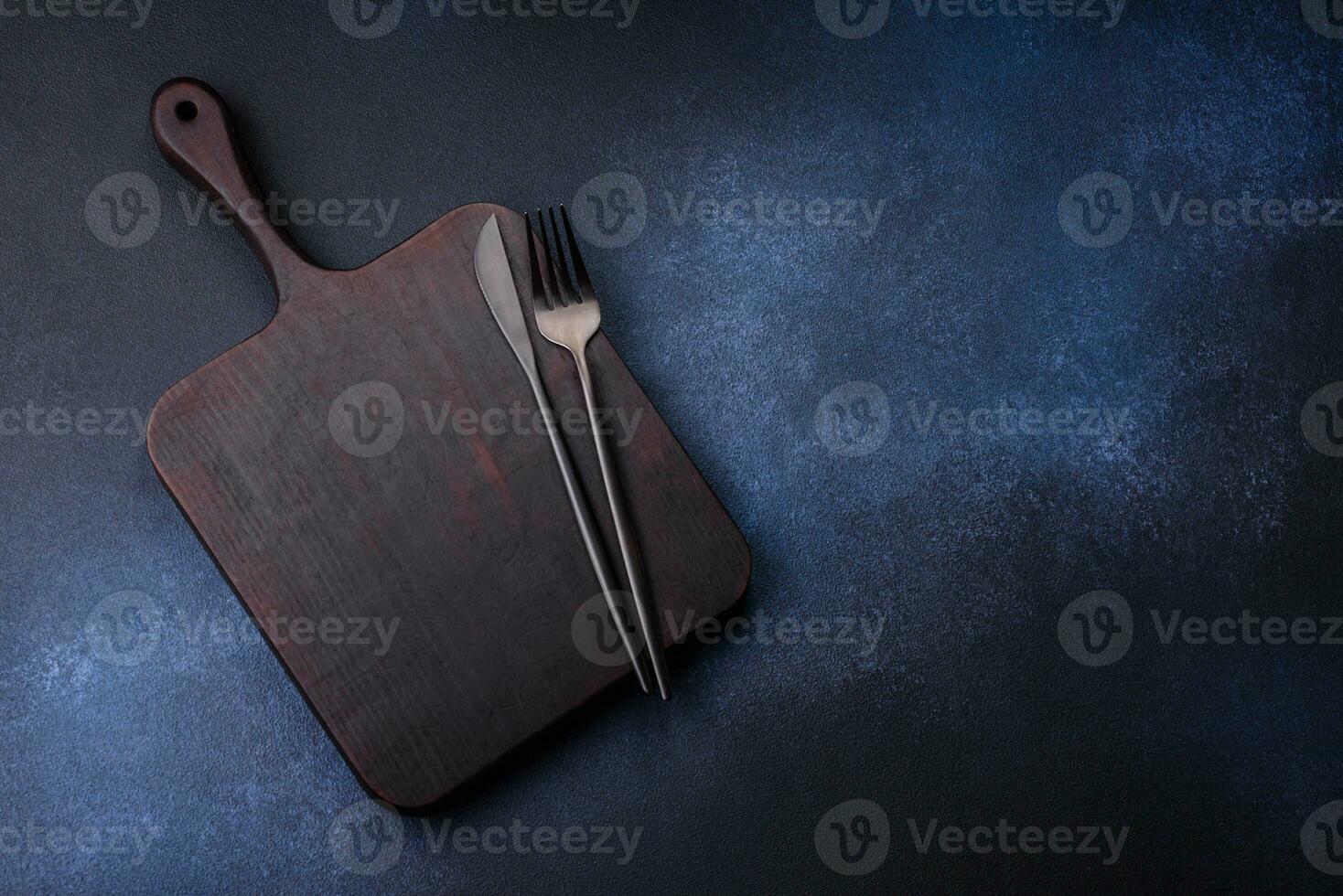 Empty rectangular wooden cutting board on dark concrete background photo