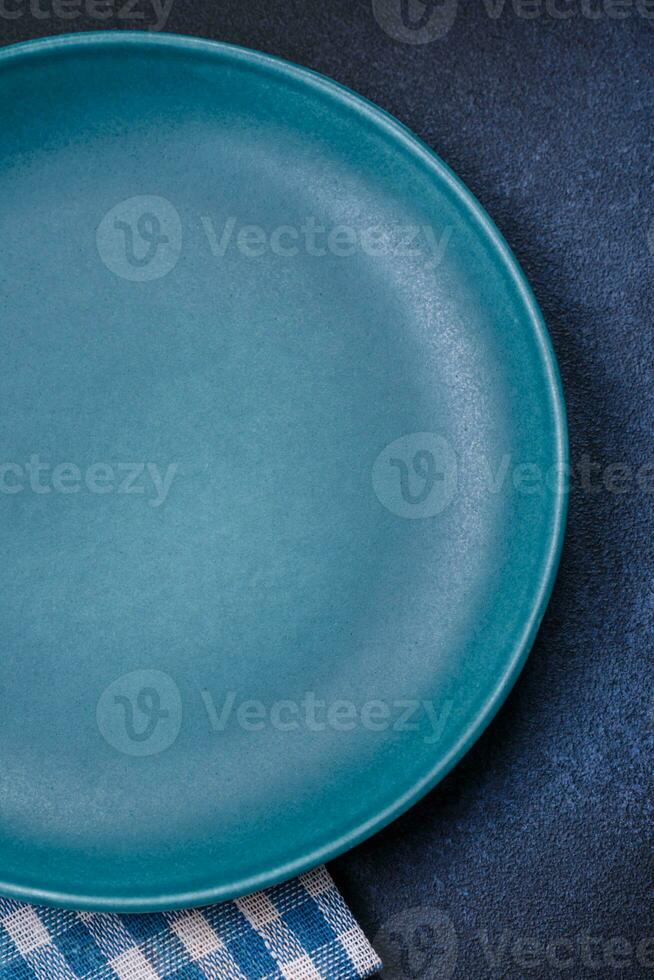 Round empty colored ceramic plate on concrete texture background photo