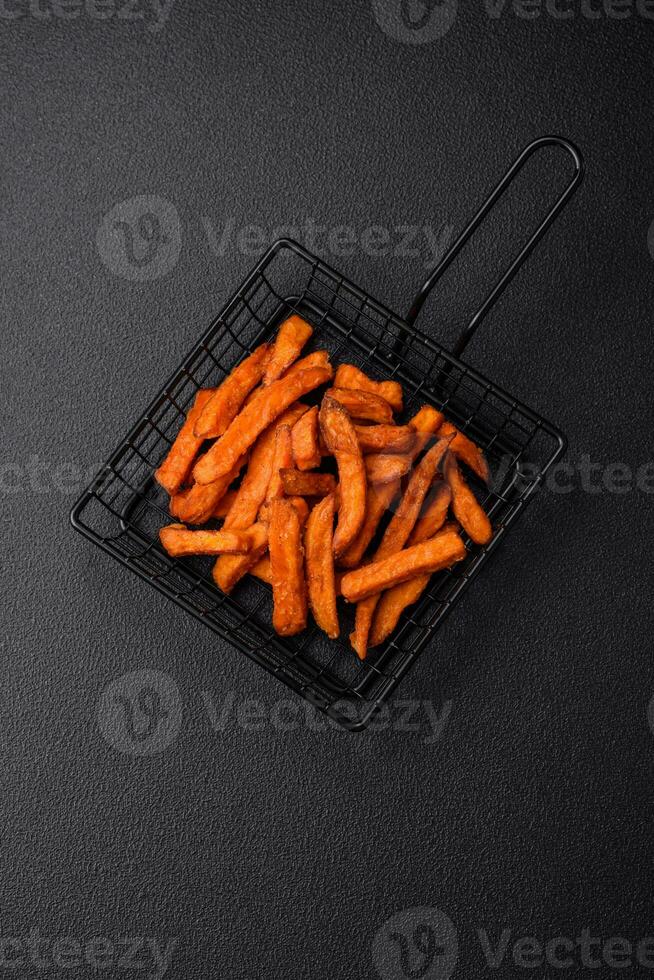 Delicious crispy sweet potato fries with salt, spices and herbs photo