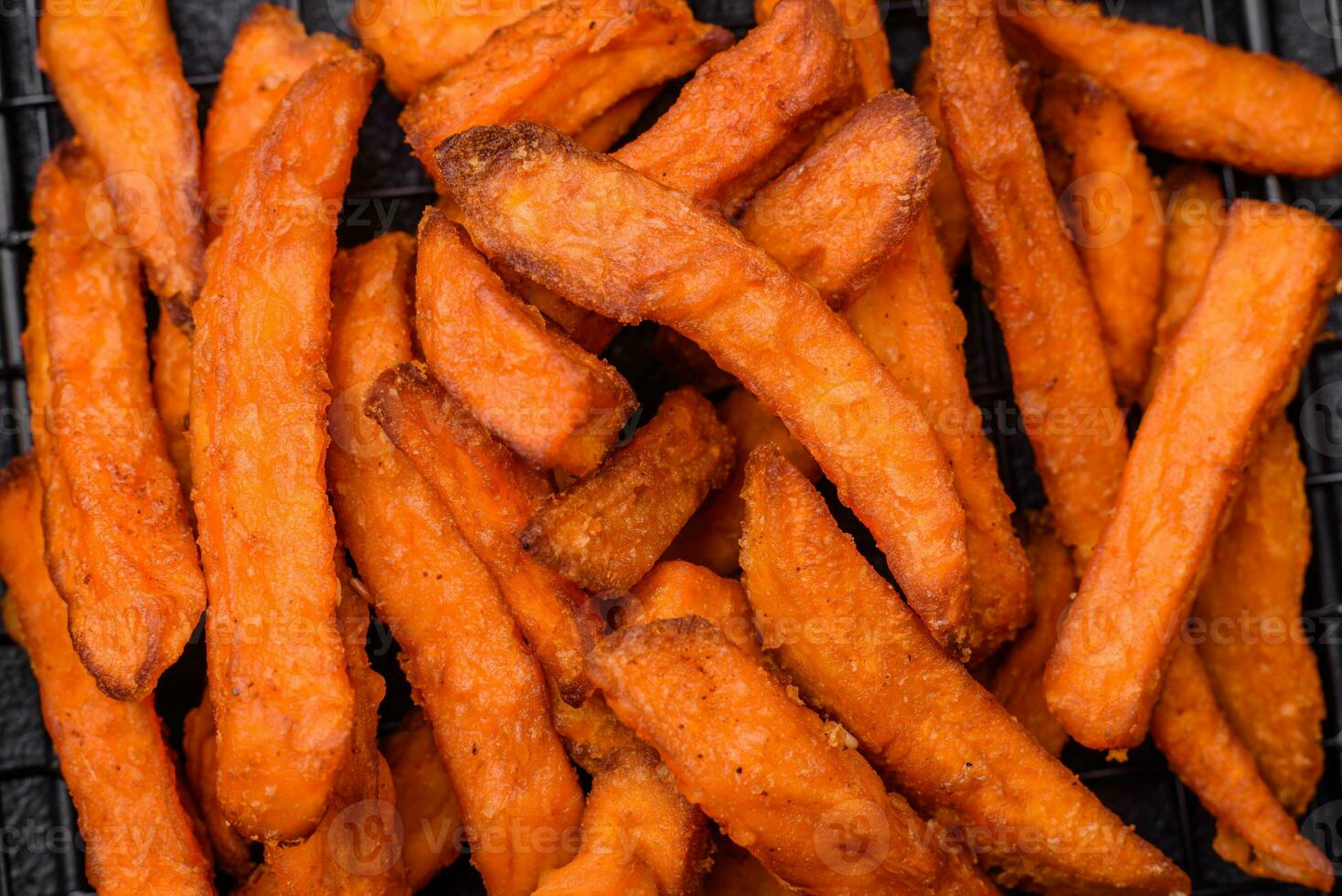 Delicious crispy sweet potato fries with salt, spices and herbs photo