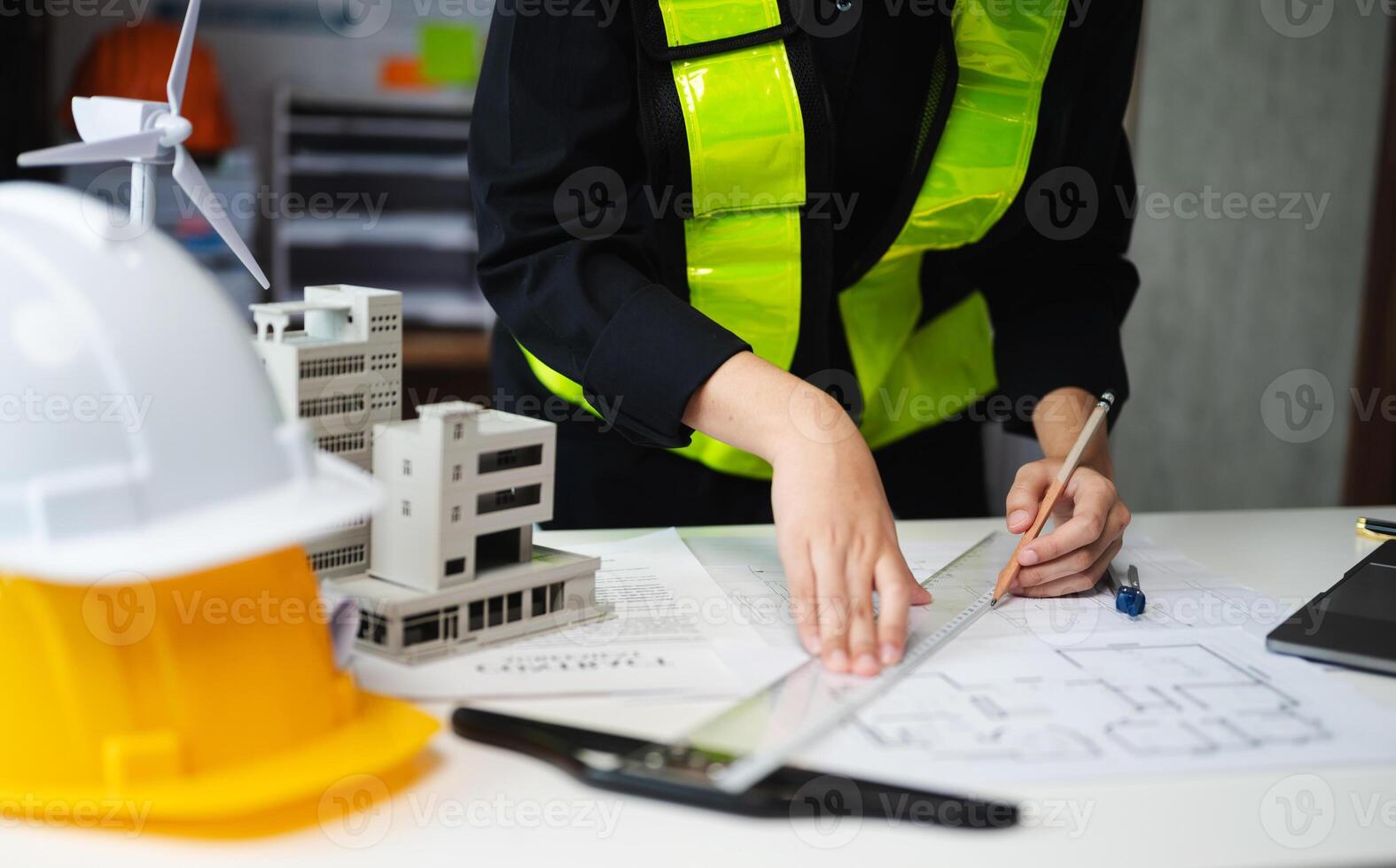 business man hand working and laptop with on on architectural project at construction site at desk photo