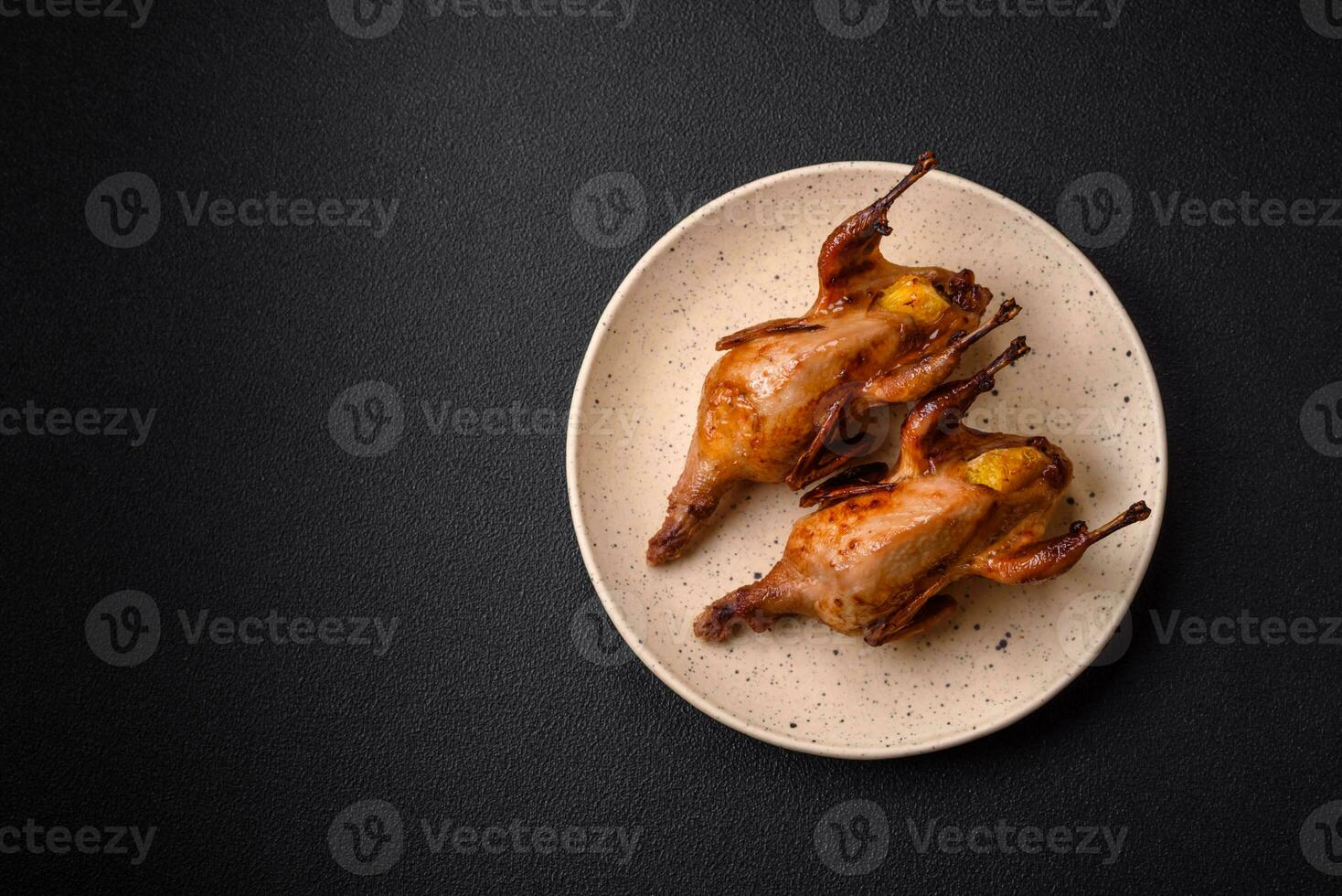 Roasted quail, partridge or pigeon stuffed with orange with spices and herbs photo