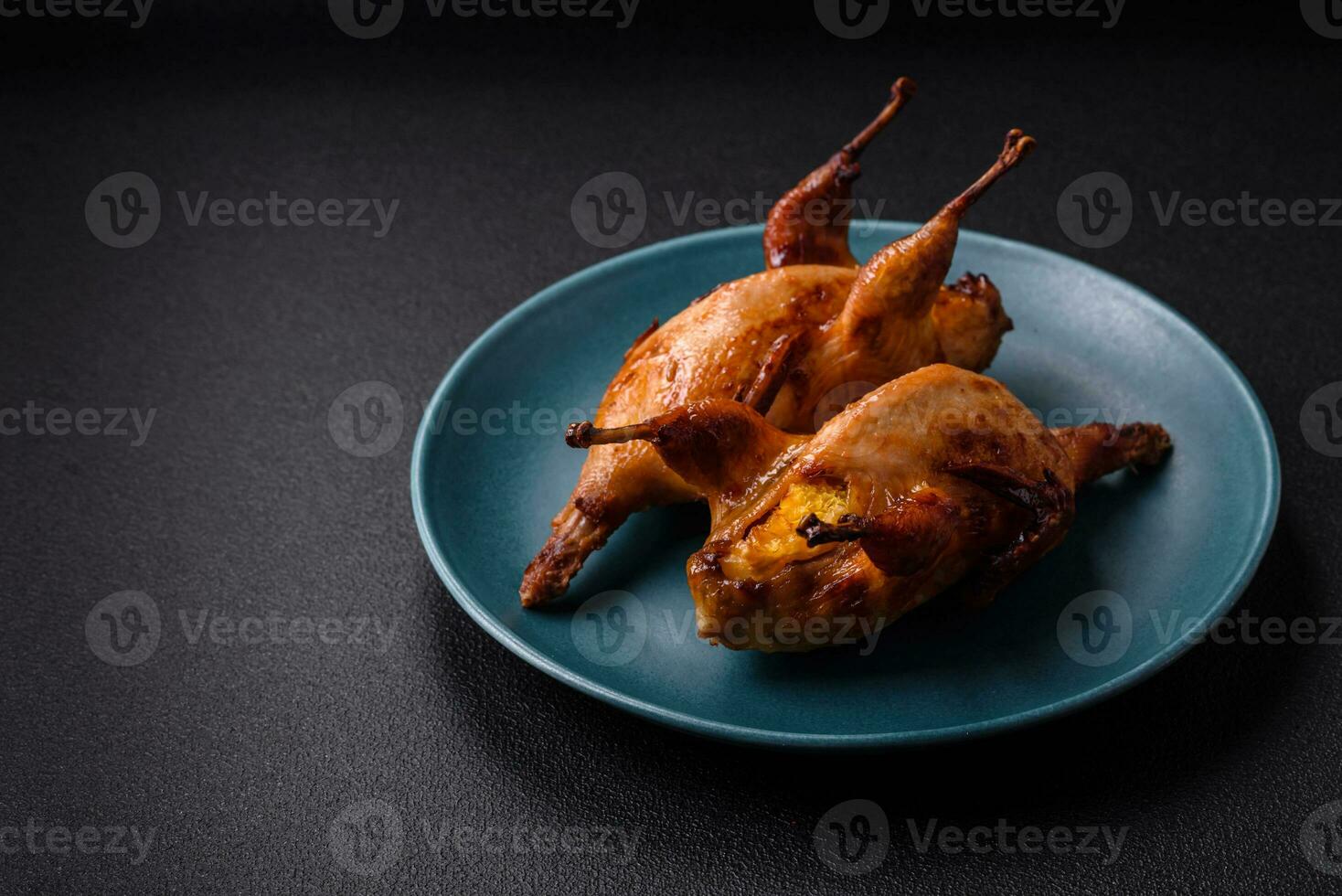 Roasted quail, partridge or pigeon stuffed with orange with spices and herbs photo