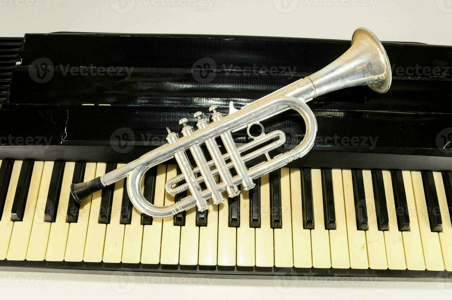 a silver trumpet on top of a piano keyboard photo
