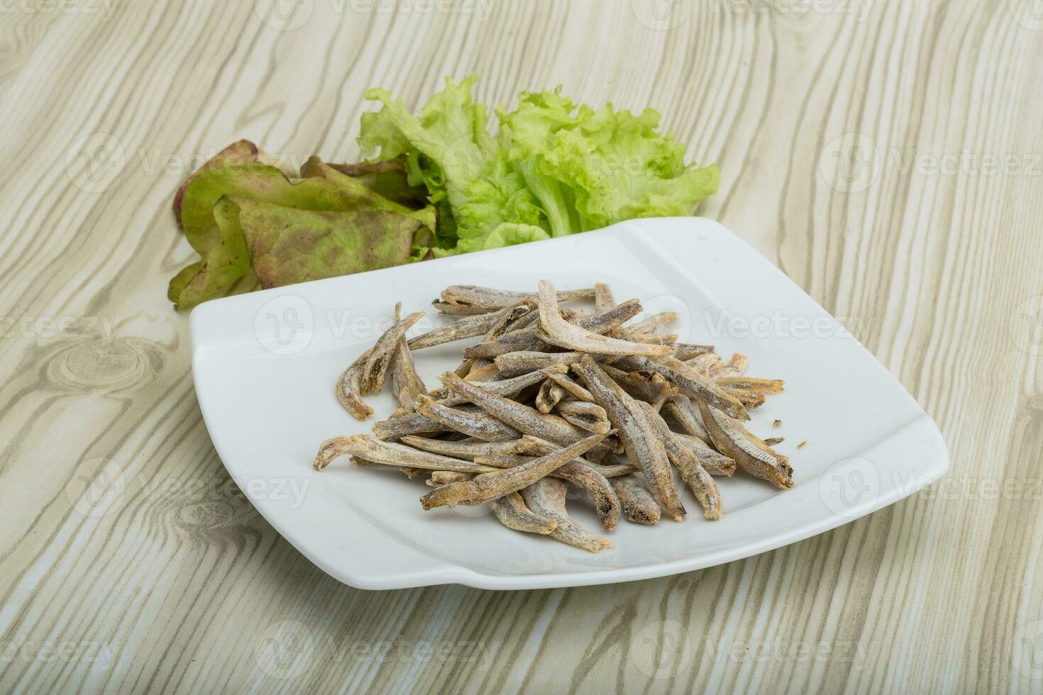Dries anchovy over wooden background photo