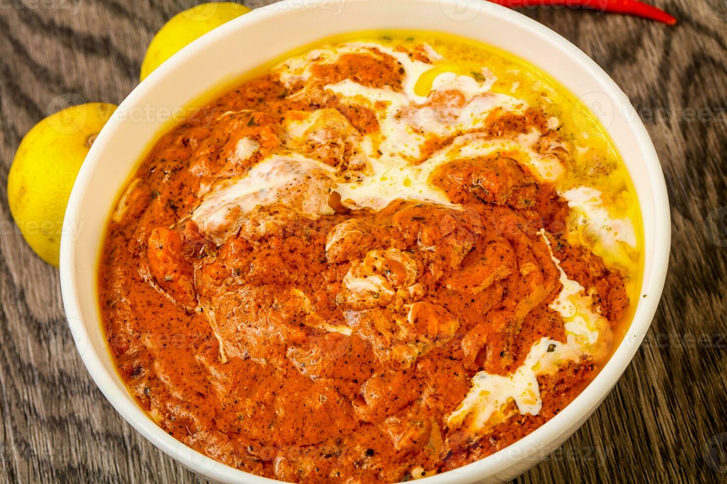 Butter chicken over wooden background photo