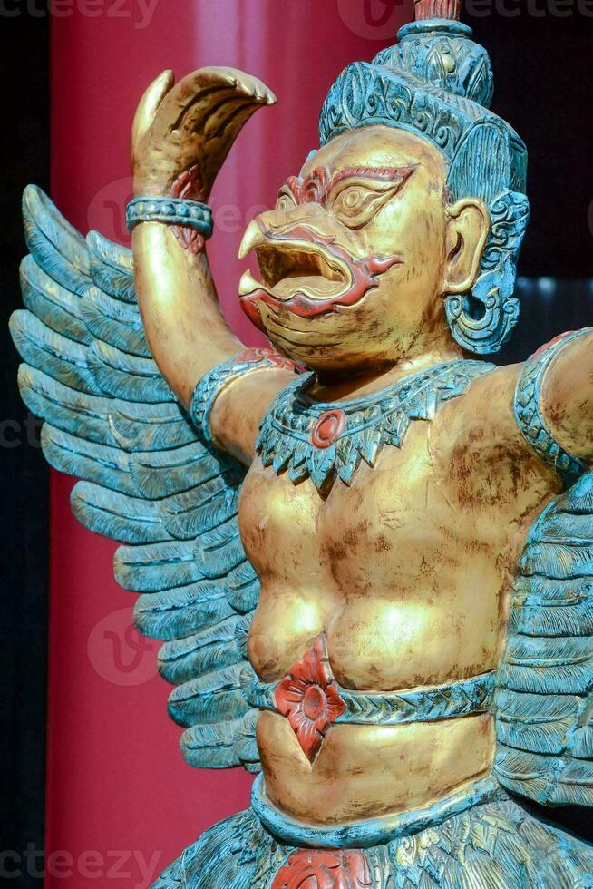 a statue of a man with wings and a red background photo