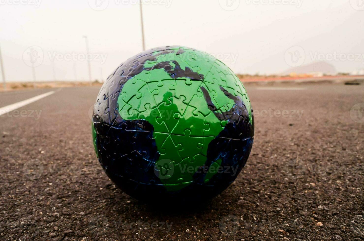 a puzzle piece globe in the middle of a road photo