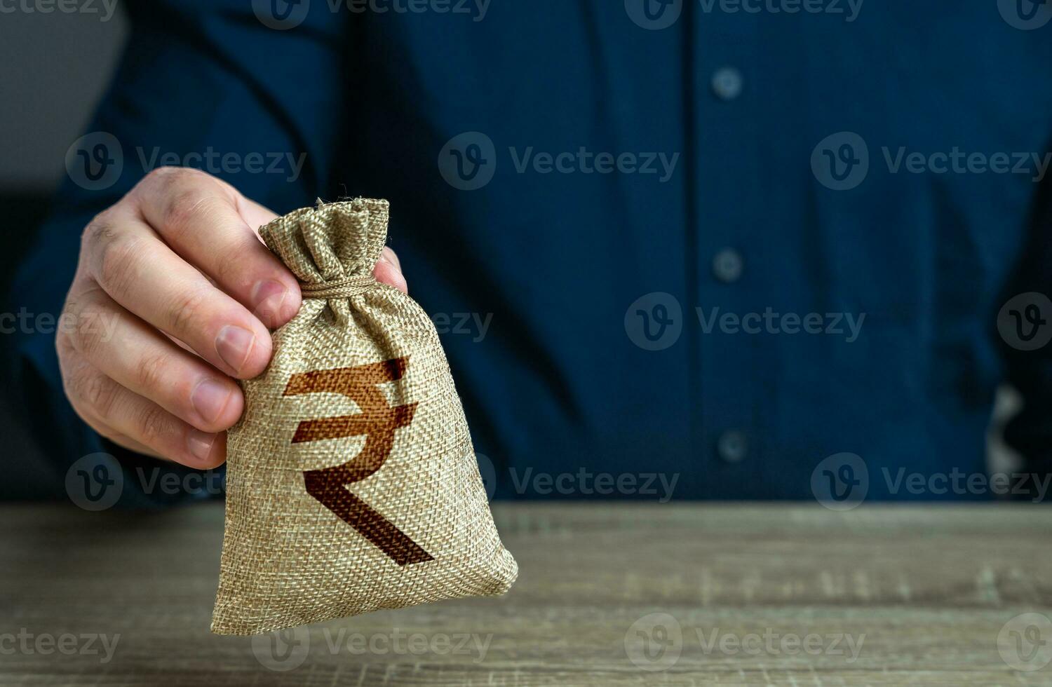 A man holds an indian rupee money bag. Deposits and savings. Loans