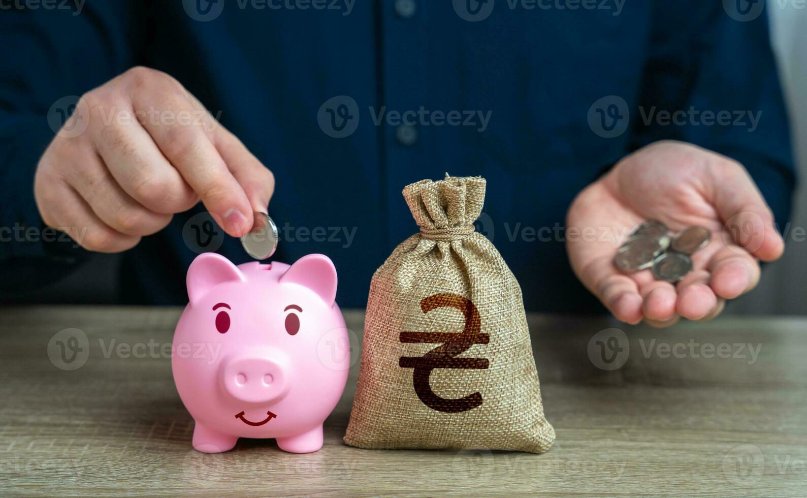 A man collects Ukrainian hryvnias in a piggy bank. Accumulating money. Savings and investments. Bank deposit. Raise funds for your dream. Reduce costs. Save for retirement. Collection of donations. photo