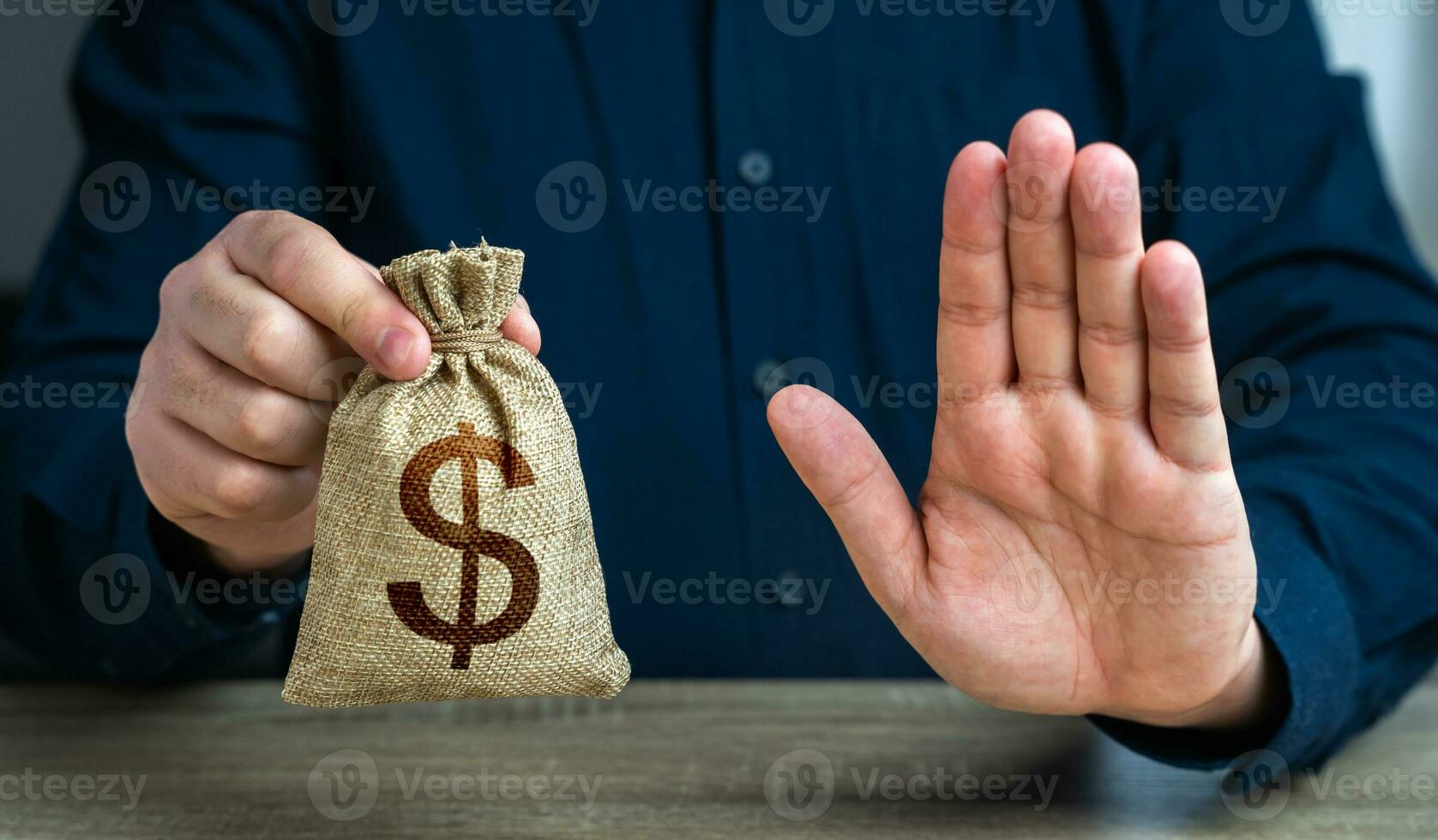 Stop gesture and dollar money bag. The man does not approve of the transaction or loan. Financial difficulties. Asset freeze seizure. Economic sanctions, confiscation of funds. photo