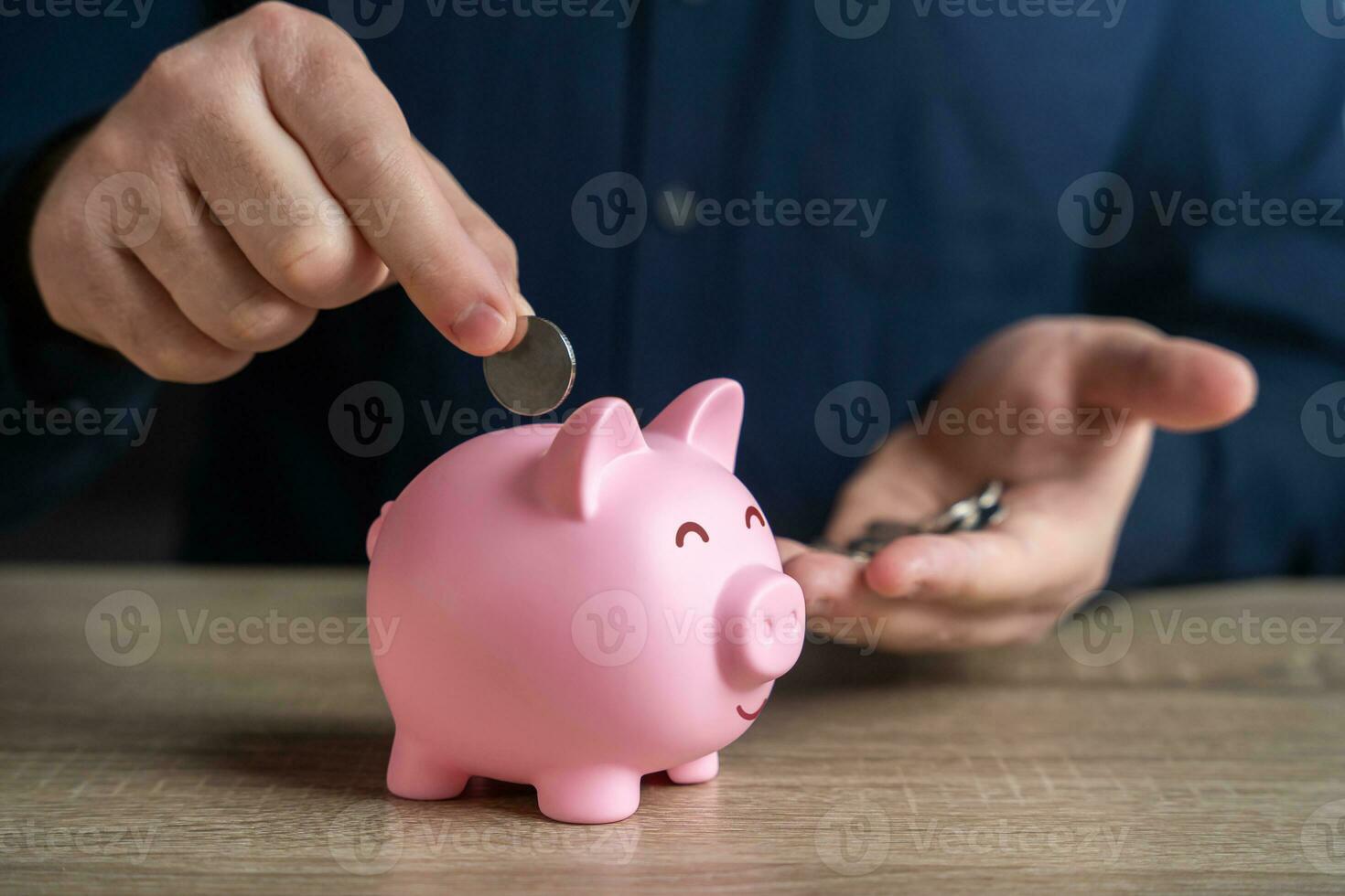 A man puts coins in a piggy bank. Accumulating money. Savings and investments. Collection of donations. Bank deposit. Raise funds for your dream. Reduce costs. Save for retirement. photo