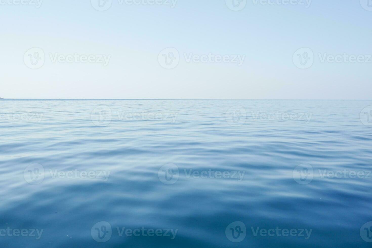 Horizontal line of calm sea surface on the day light. Sea on blue sky background. Seascape in early morning hours under clear sky. photo