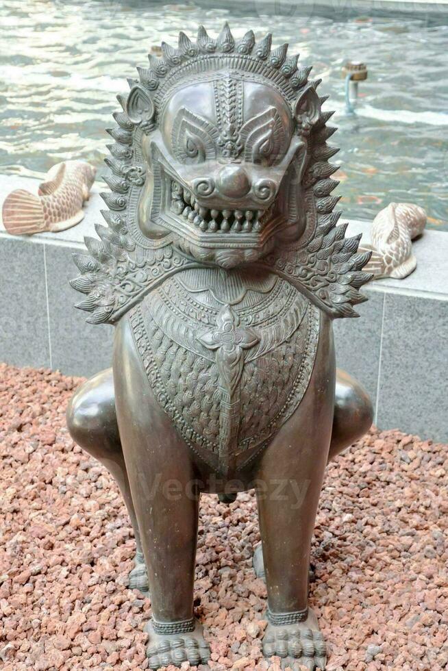 a statue of a lion sitting on stones photo