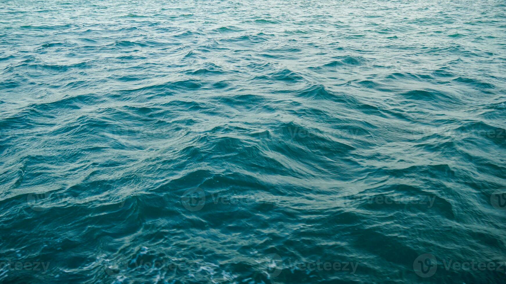 Top view of the turquoise water. Like a background. Small waves create ripples on the sea and change color. Gradient from turquoise to dark blue in places. Clean ocean. The background photo. photo