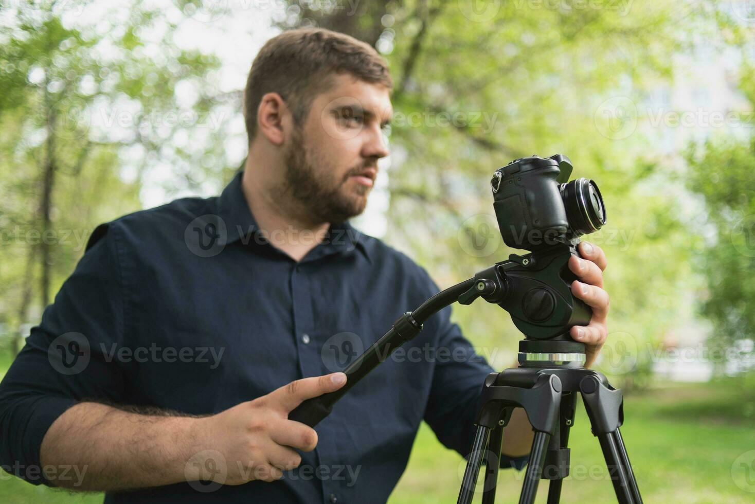 Videographer shoots video in a green park. photo