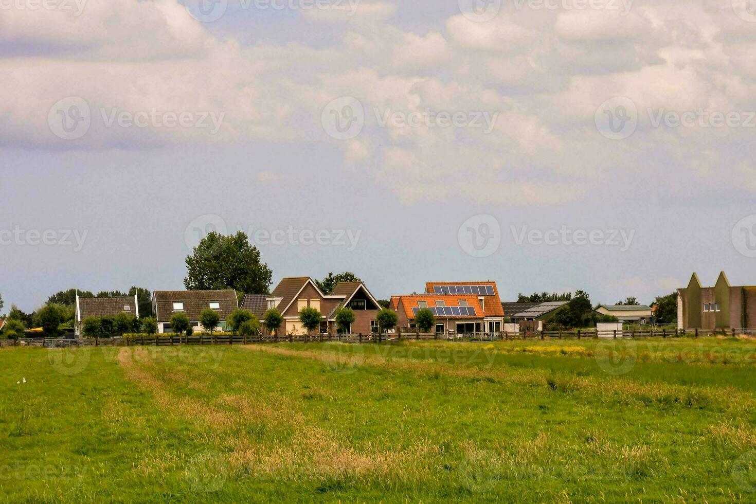 a field with houses and a church in the background photo