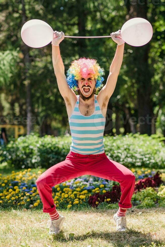 Mime performs in the park with balloons. Clown shows pantomime on the street. photo