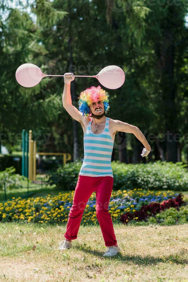 Mime performs in the park with balloons. Clown shows pantomime on the street. photo