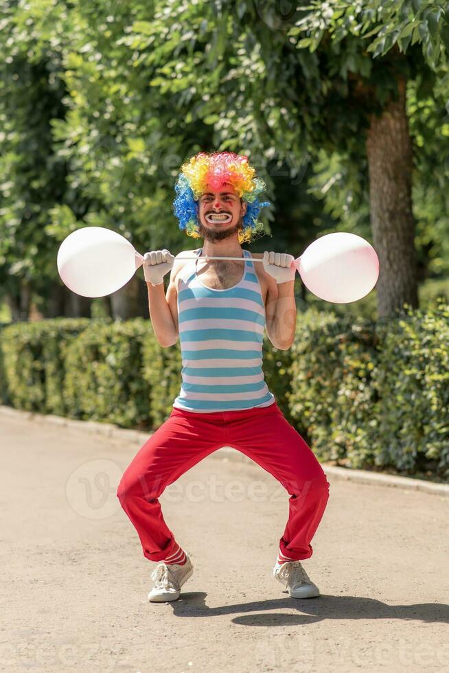 Mime performs in the park with balloons. Clown shows pantomime on the street. photo