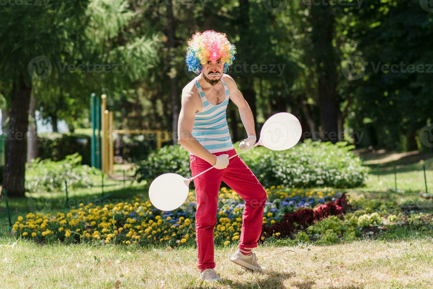 Mime performs in the park with balloons. Clown shows pantomime on the street. photo