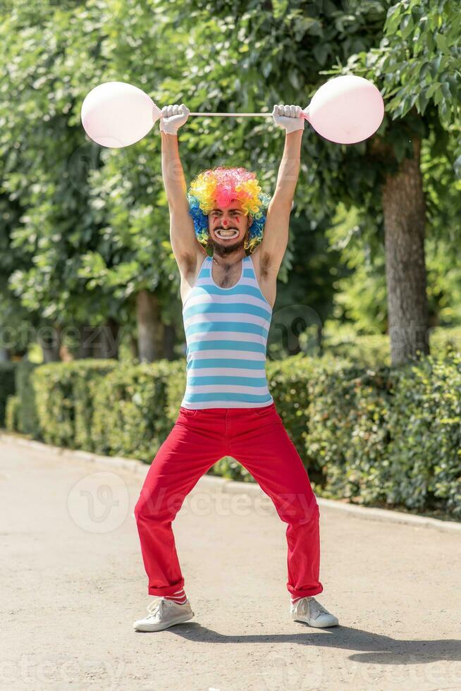 Mime performs in the park with balloons. Clown shows pantomime on the street. photo