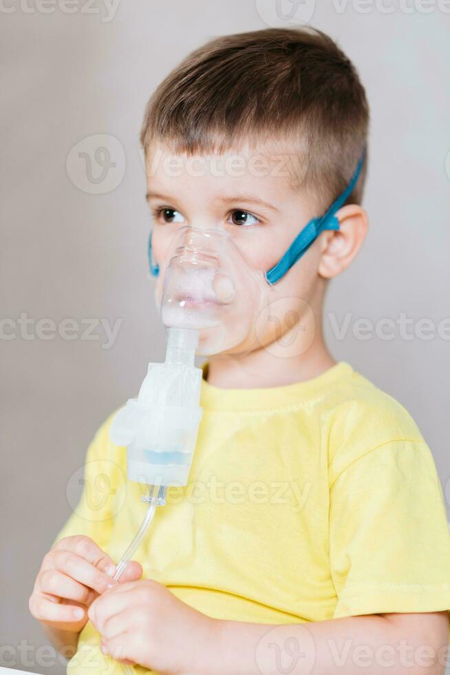 small child treats bronchitis inhaler at home photo