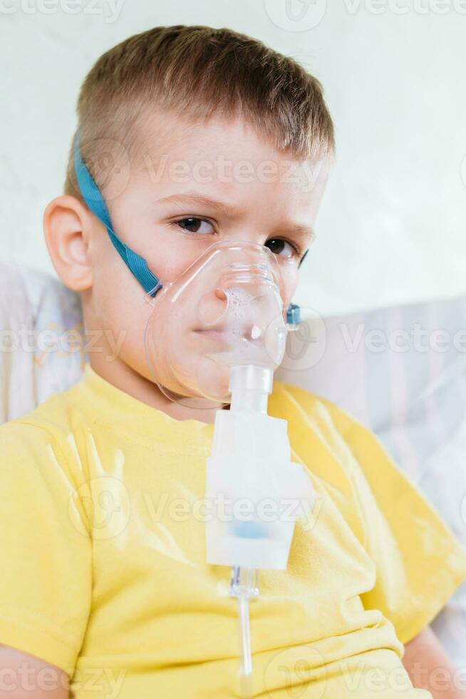 small child treats bronchitis inhaler at home photo