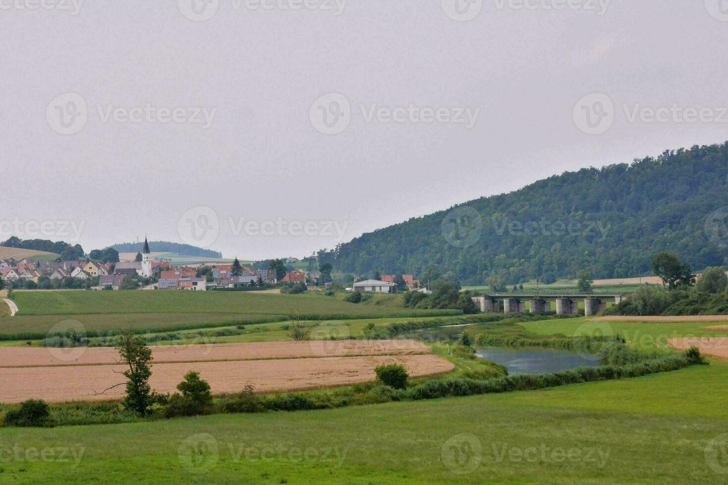 a view of a village and a river in the countryside photo