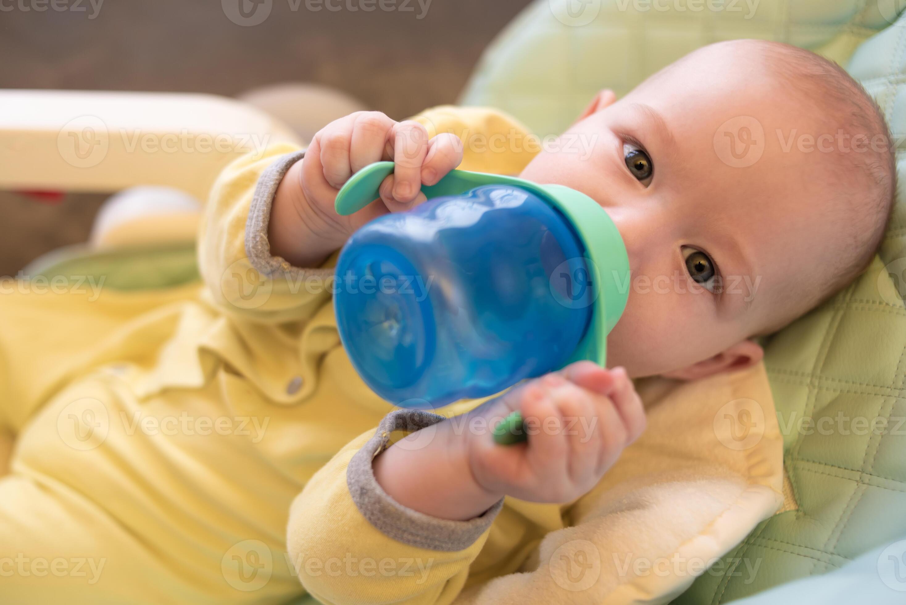 The baby drinks water from a bottle. 34732600 Stock Photo at Vecteezy