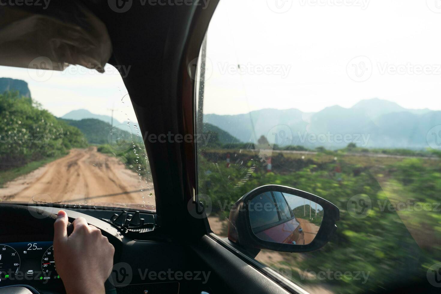 The car's backside, adorned with tree reflections from the road. Dirty Rural Road In Summer Field, Meadow, mountain, Countryside. View From Car Window. Freedom And Dream Concept. photo