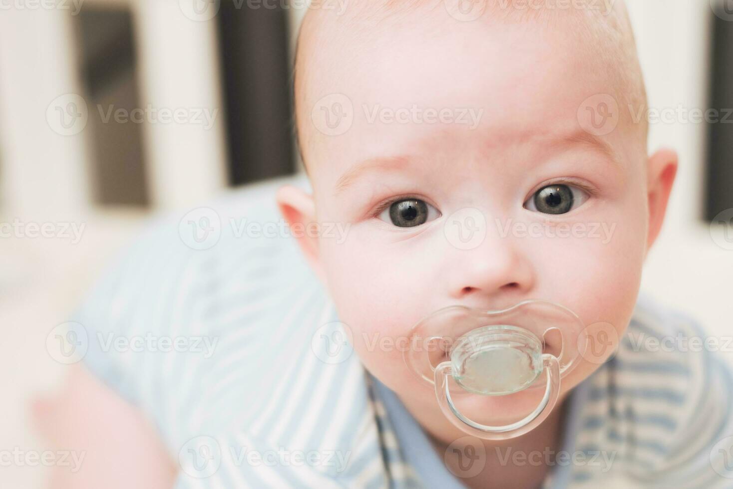 The child lies in a crib on his abdomen. photo